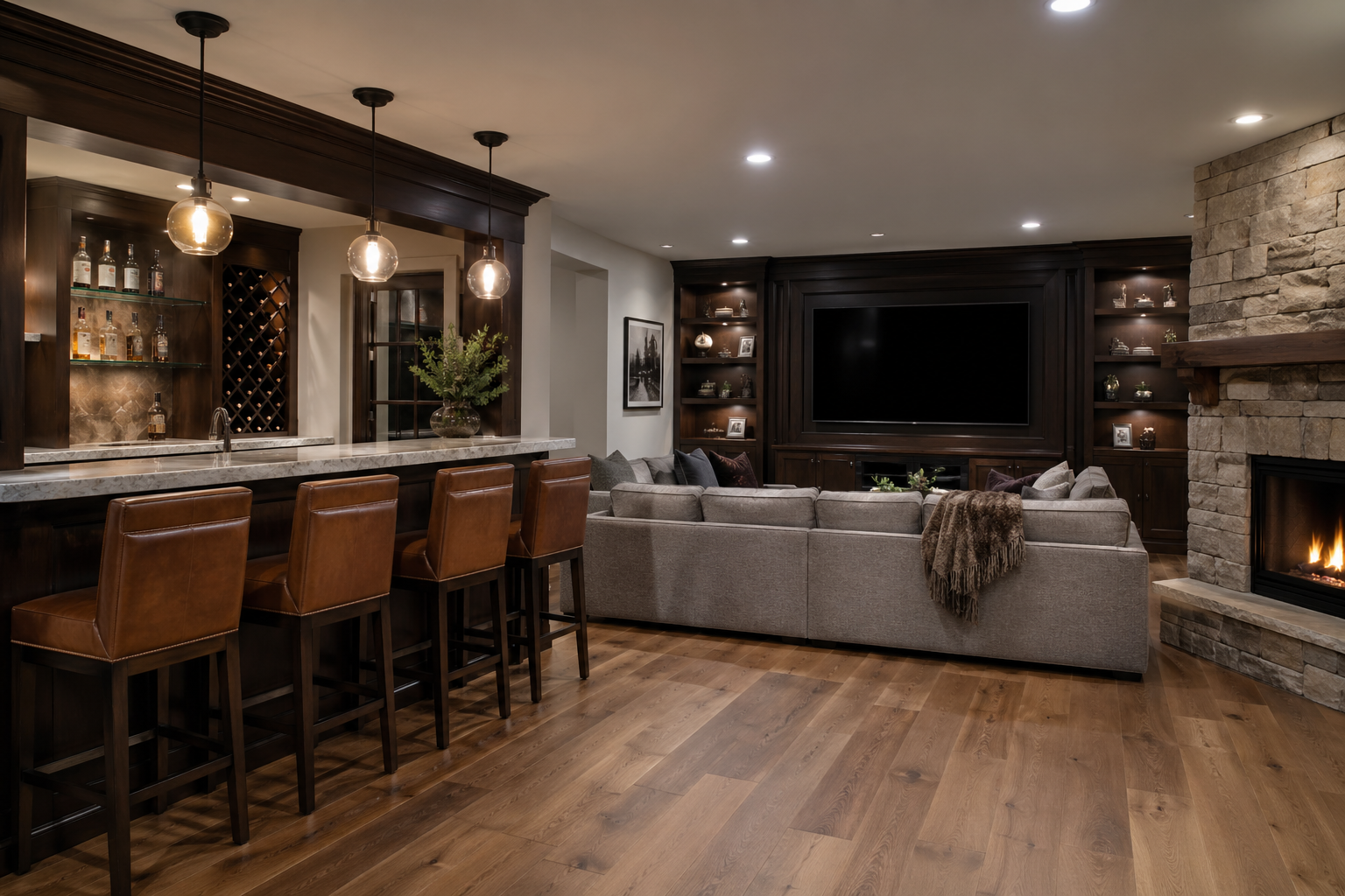 Custom Brookhaven GA basement entertainment area with walnut bar, stone fireplace, sectional, and wall-mounted TV
